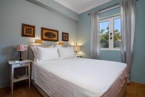 a bedroom with a large white bed and a window at La Villetta in Lagópodhon +38 photos