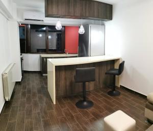 a kitchen with a counter and two bar stools at Mara Park in Baia Mare