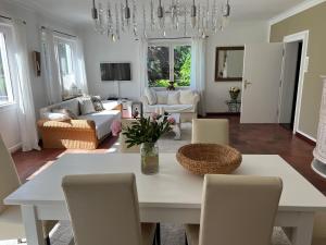 sala de estar con mesa blanca y sillas en Villa am Bach en Unterwössen