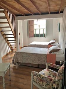 a bedroom with two beds and a couch at Hostal Latina in Cuenca