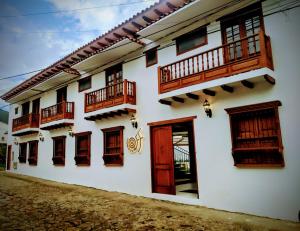 a white building with wooden doors and windows at OFF HOSTEL in Villa de Leyva