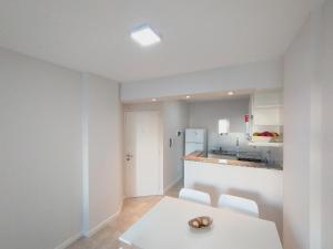 a white kitchen with a table and a counter at Depto Moreno in Rosario
