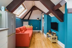 a living room with a red couch and blue walls at Sunny Loft in Center of London in London
