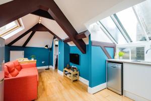 ein Wohnzimmer mit blauen Wänden und einem roten Sofa in der Unterkunft Sunny Loft in Center of London in London