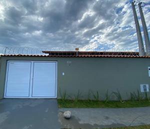 um edifício branco com duas portas de garagem em Casa com piscina e 2 quartos Itanhaém em Itanhaém