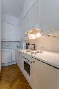 ウィーンにあるBeautiful Apartment City Center 4の白いキッチン(白い家電製品、白いキャビネット付)