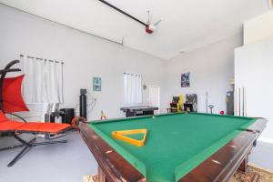 a room with a pool table and a chair at Luxury Ocean Blue beach house- 3 bed room Dog friendly in Palm Coast