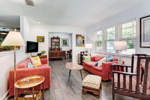 a living room with two red couches and a tv at Private Pool - ADA - Pet Friendly - Fenced Yard - 884 Oak Lane in Fernandina Beach