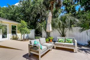 a patio with two chairs and an umbrella at Private Pool - ADA - Pet Friendly - Fenced Yard - 884 Oak Lane in Fernandina Beach