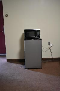 a microwave sitting on top of a small refrigerator at South Hills Motel in Pittsburgh