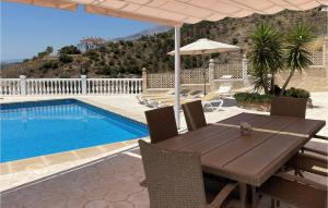 a table with an umbrella and a swimming pool at Casa Anttonio in Cómpeta