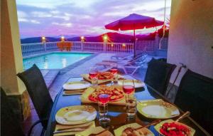 a table with food and wine glasses and a swimming pool at Casa Anttonio in Cómpeta