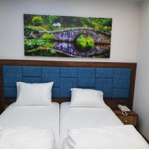 two beds in a room with a painting on the wall at seyir yeri otel cafe&restorant in Trabzon