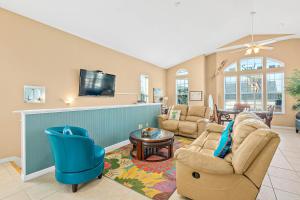sala de estar con 2 sillas y TV en Island Breeze, en St. Augustine
