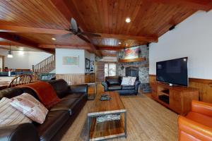 un soggiorno con divano e TV di Luxury Adirondack Lakeview a Gilford