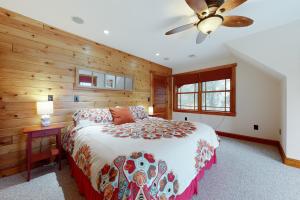 una camera con letto e ventilatore a soffitto di Luxury Adirondack Lakeview a Gilford