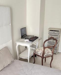 カンヌにあるDuplex à la Villa Canteraineのベッドルーム(ノートパソコンと椅子付きのデスク付)