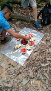 a young boy is preparing food on a table at Bukit Lawang Glamping & Jungle Trekking in Bukit Lawang