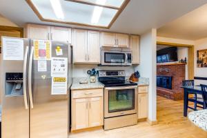 a kitchen with stainless steel appliances and wooden cabinets at Time Out in Joseph +17 photos