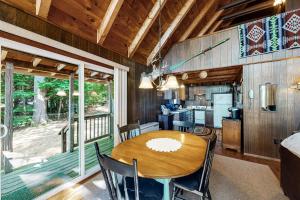 a dining room and kitchen with a table and chairs at Cabin on Long Pond in Cornish