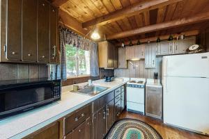 a kitchen with wooden cabinets and a white refrigerator at Cabin on Long Pond in Cornish +47 photos