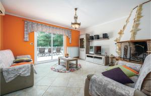 a living room with orange walls and a couch and a table at Nice Home In Vinez With 3 Bedrooms, Wifi And Outdoor Swimming Pool in Vinež