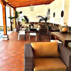 un salon avec un canapé sur la terrasse dans l'établissement Casa Rural Los Olmos, à La Codosera