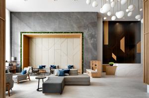 Un vestíbulo con un sofá, una mesa y sillas. en Hyatt Place Montreal - Downtown, en Montreal