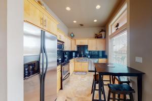 a kitchen with a stainless steel refrigerator and a table at South Pacific Escape 1 & 2 in Rockaway Beach