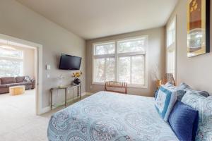 a bedroom with a bed and a couch and windows at South Pacific Escape 1 & 2 in Rockaway Beach