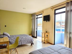 a bedroom with a bed and a desk and a television at Hotel Galaxia in Oaxaca City