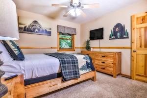 - une chambre avec un lit et un ventilateur de plafond dans l'établissement Bear Paw Hideaway, à Lac du Flambeau