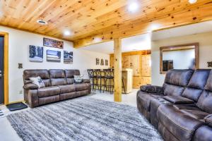 ein Wohnzimmer mit Ledermöbeln und Holzdecken in der Unterkunft Bear Paw Hideaway in Lac du Flambeau