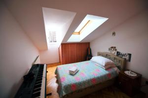 um quarto com uma cama ao lado de um piano em Apartment Fiumara em Rijeka