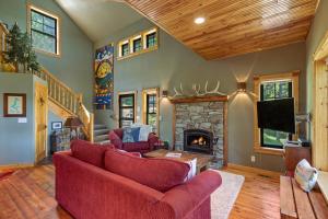 ein Wohnzimmer mit einem roten Sofa und einem Kamin in der Unterkunft Stoneridge Pines Cabin in Harrison
