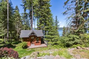 eine Hütte im Wald mit Seeblick in der Unterkunft Stoneridge Pines Cabin in Harrison