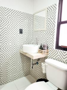 a bathroom with a white toilet and a sink at H. Galaxia in Oaxaca City
