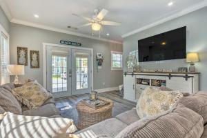 a living room with two couches and a flat screen tv at Sunny Perdido Key Cottage with On-Site Tiki Bar in Pensacola