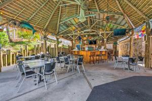 ペンサコーラにあるSunny Perdido Key Cottage with On-Site Tiki Barのテーブルと椅子のあるレストラン、バー