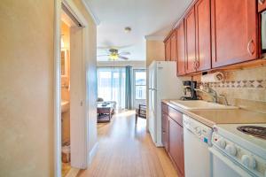 a kitchen with wooden cabinets and a white refrigerator at Beautiful Brigantine Condo - Walk to Beach! in Brigantine +16 photos