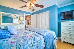 a bedroom with blue walls and a bed and a ceiling fan at Beautiful Brigantine Condo - Walk to Beach! in Brigantine