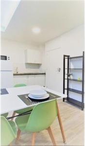 ein Esszimmer mit einem Tisch und grünen Stühlen in der Unterkunft Coqueto apartamento nuevo en pleno centro de Algeciras BB in Algeciras