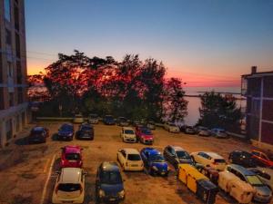 eine Gruppe von Autos, die bei Sonnenuntergang auf einem Parkplatz geparkt werden in der Unterkunft Casa Scotty 2 in Ancona