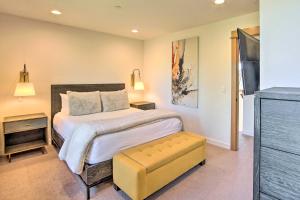 Un dormitorio con una cama grande y un taburete amarillo en Charming Cle Elum Townhome with Balcony and Views, en Cle Elum