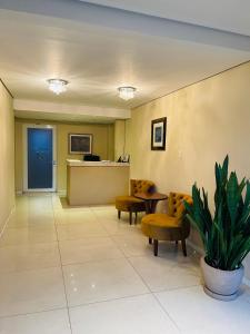 a waiting room with chairs and a reception desk at Hotel Palmeiras in Santana do Livramento