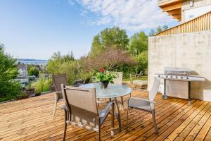 a patio with a table and chairs on a wooden deck at Downtown Contemporary Coastal Condo in Anchorage