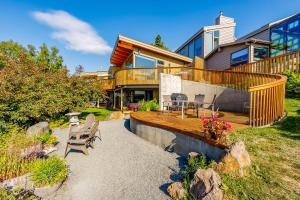 une maison avec une terrasse et des chaises devant elle dans l'établissement Downtown Contemporary Coastal Condo, à Anchorage