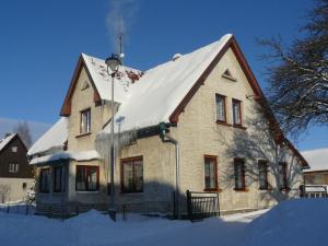 ein Haus mit einem schneebedeckten Dach in der Unterkunft Apartmány Sněženka in Deštné v Orlických horách