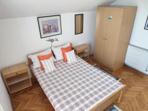 Schlafzimmer mit einem Bett mit orangefarbenen und weißen Kissen in der Unterkunft Smestaj Vella in Herceg-Novi