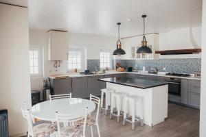 a kitchen with a table and chairs and a counter top at Villa Tumbine in Cascais